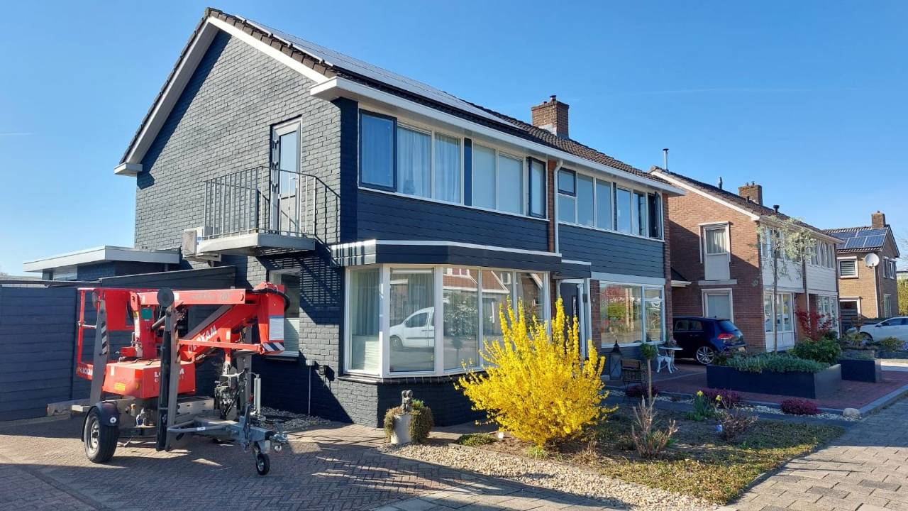 Woning met antracietgrijze gevel en frisse witte kozijnen na schilderwerk